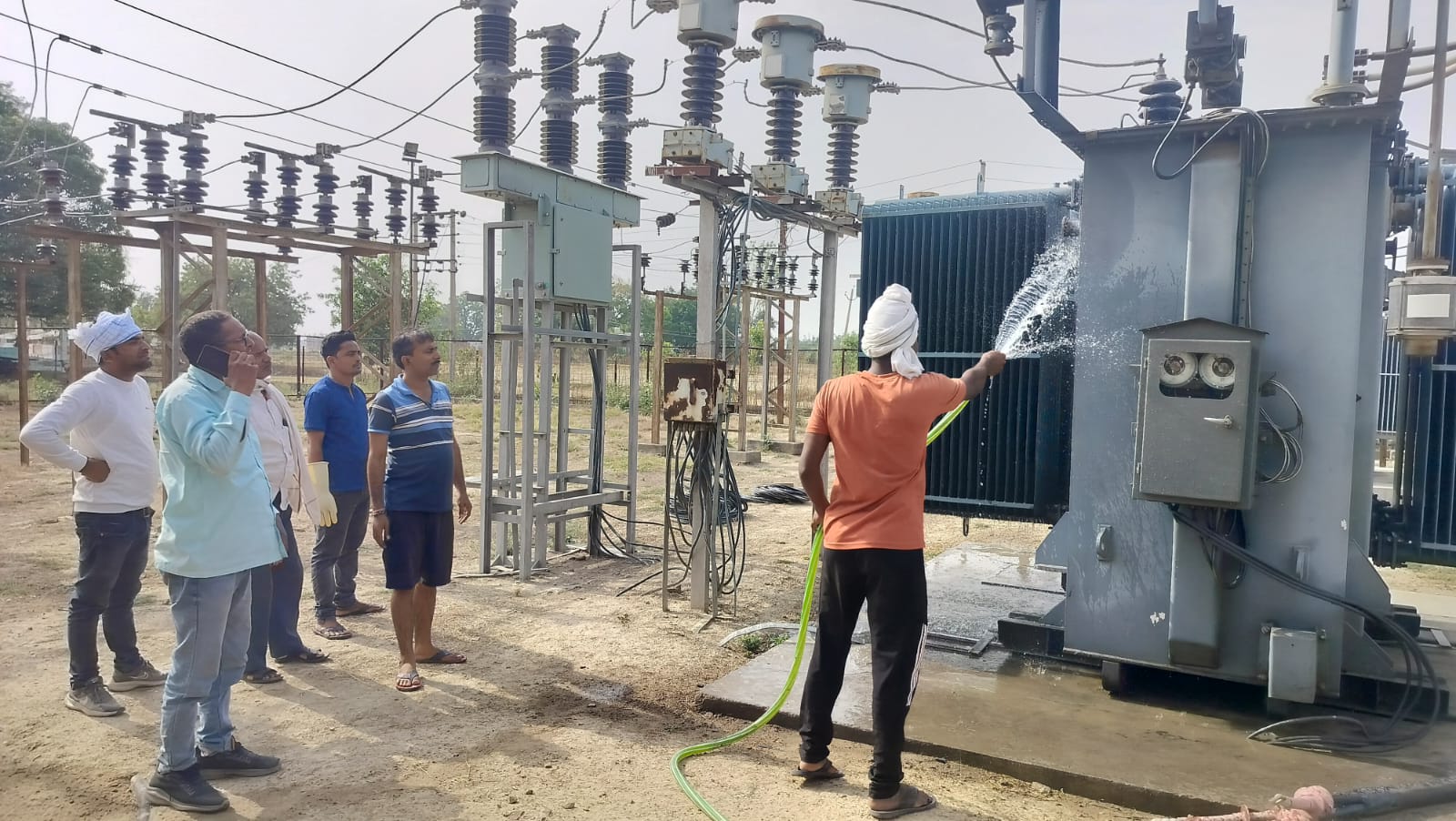 ट्रांसफार्मर की तपन से ठप हो रही बिजली, पानी डालकर ठंडा कर रहे कर्मचारी ट्रांसफार्मर की तपन से ठप हो रही बिजली, पानी डालकर ठंडा कर रहे कर्मचारी