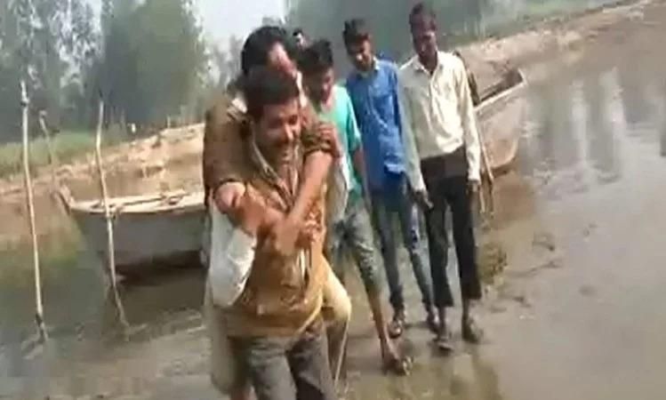 दरोगा की बेशर्मी -जूते बचाने के लिए युवक के कंधों पर बैठकर दरोगा ने पार किया नदी किनारा
