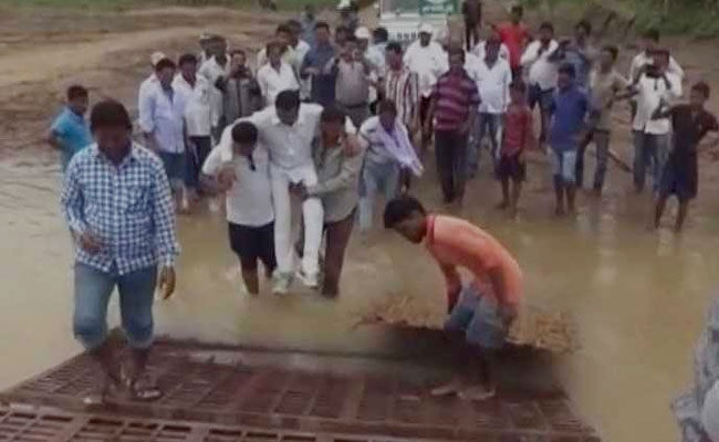 ओडिशा के विधायक को गोद में उठाकर कीचड़ के पार ले गए समर्थक ओडिशा के विधायक को गोद में उठाकर कीचड़ के पार ले गए समर्थक